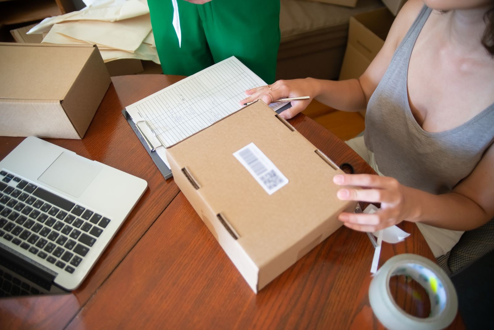 Online seller packing customer orders at a table