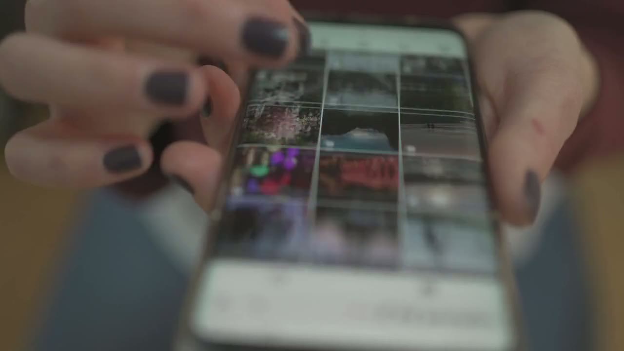 Hands scrolling a social media feed on a smartphone